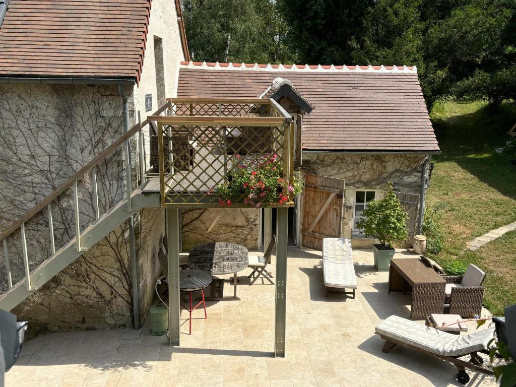 un patio avec une terrasse en bois avec un bac à fleurs dans l'établissement Moulin Les Riaux, à Châtillon-sur-Indre
