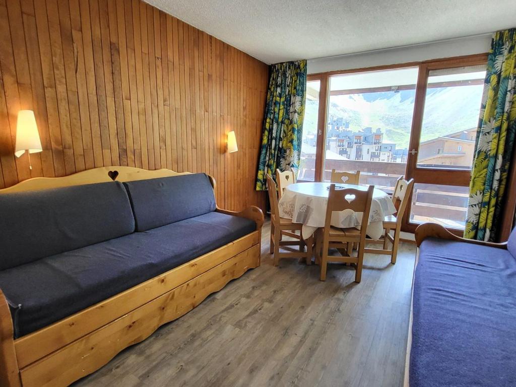 une chambre avec un lit, une table et une fenêtre dans l'établissement T2 avec balcon exposé sud à 500m des pistes - FR-1-449-167, à Tignes