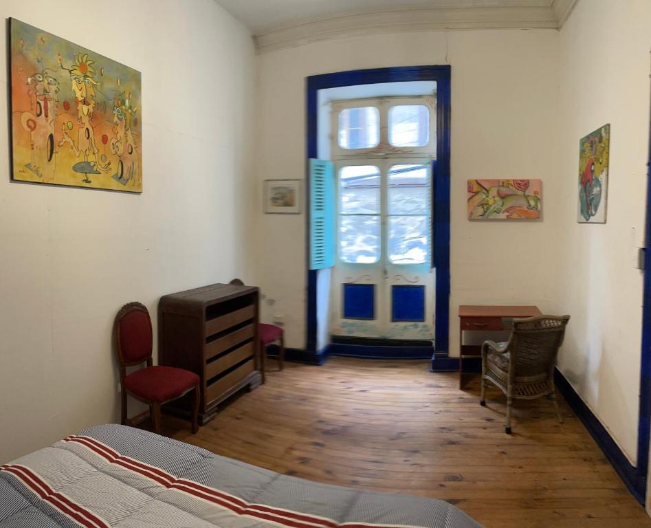 um quarto com uma cama, uma janela e uma porta em Art Hostel Casa Chaman em Valparaíso