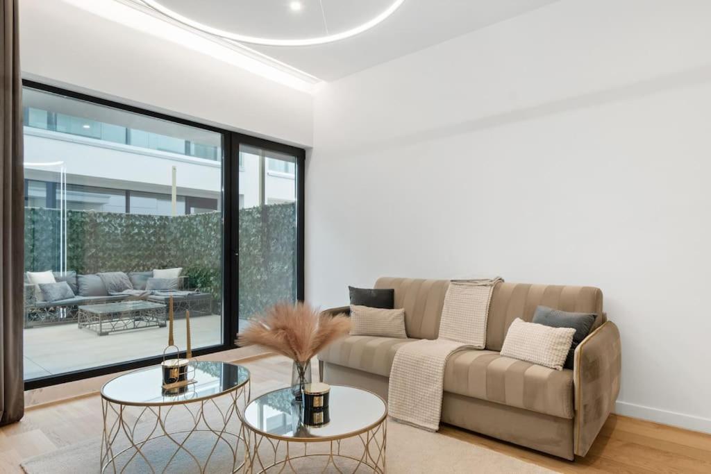 un soggiorno con un divano e due tavoli di Business Panorama Loft 5star Location, Queen Beds a Bucarest