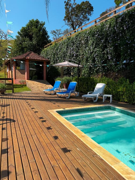 a swimming pool with two lounge chairs and a swimming pool at Pousada Shangri-lá in Cunha