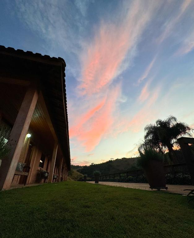 a building with a sunset in the sky at Pousada Shangri-lá in Cunha