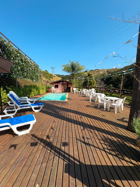 a deck with lounge chairs and a swimming pool at Pousada Shangri-lá in Cunha