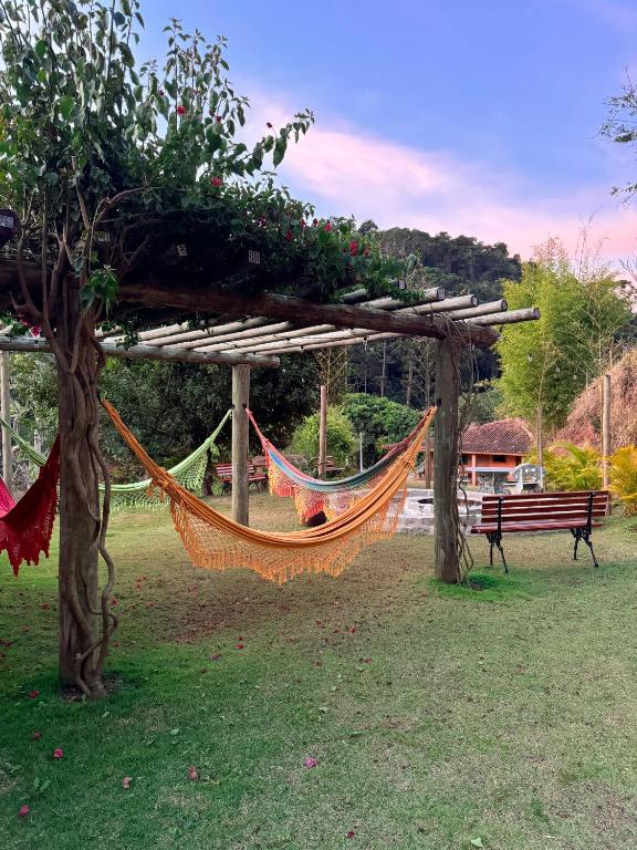 a hammock in a park next to a bench at Pousada Shangri-lá in Cunha