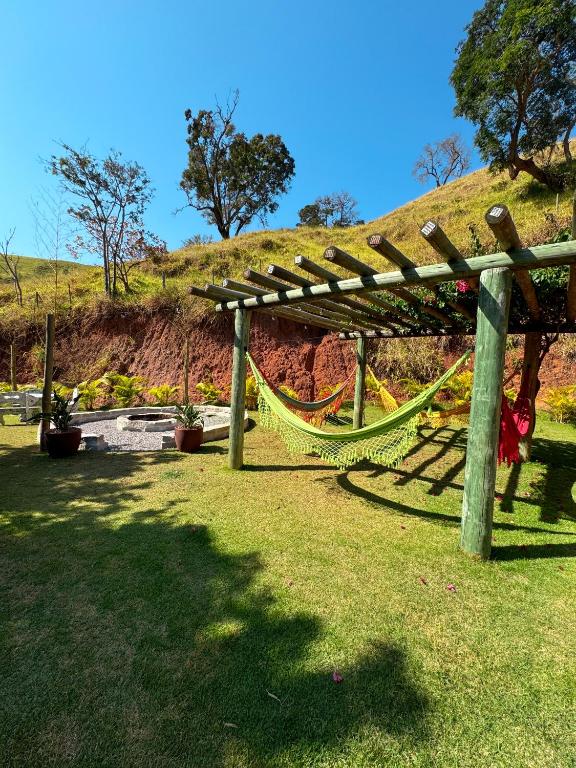 a hammock under a wooden pergola in a park at Pousada Shangri-lá in Cunha