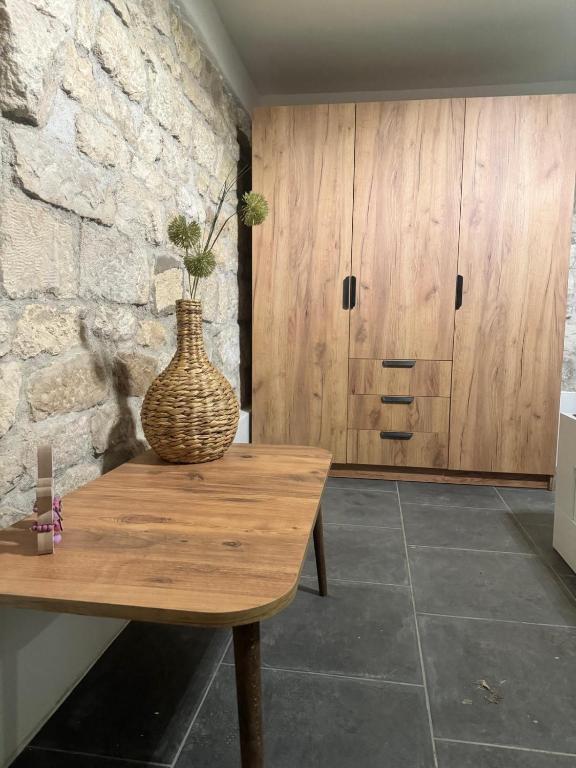 een vaas op een houten tafel in een kamer bij Yomoct in Kostandenets