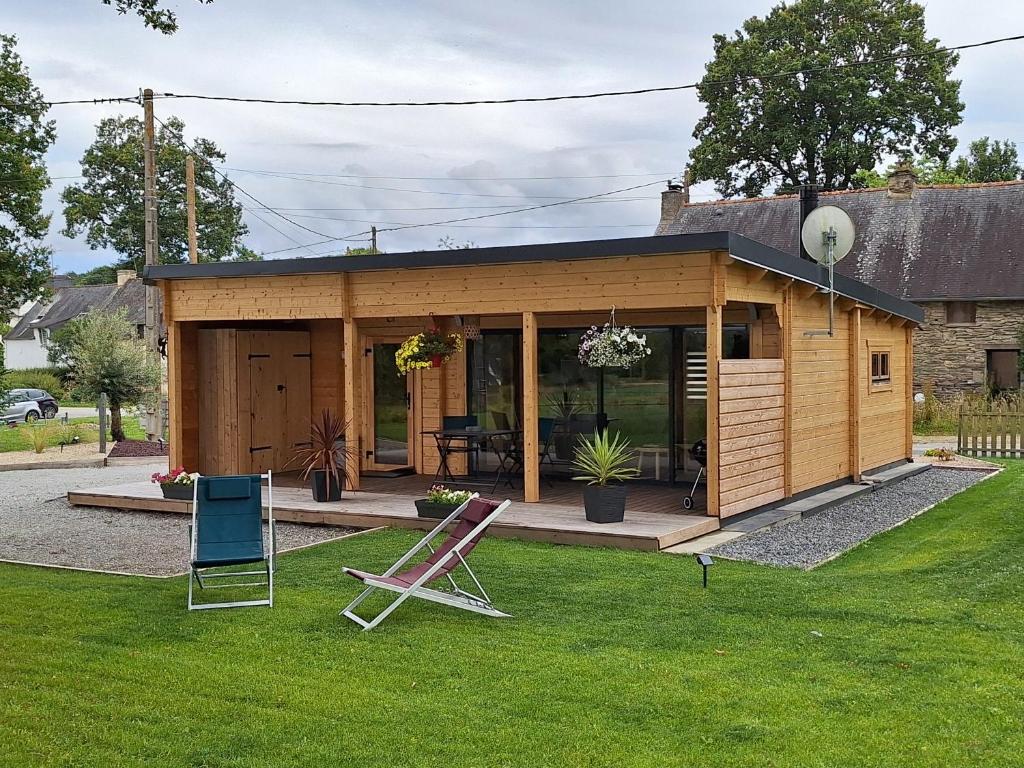 a tiny house in a garden with a lawn at Le Chalet de la Licorne in Sérent