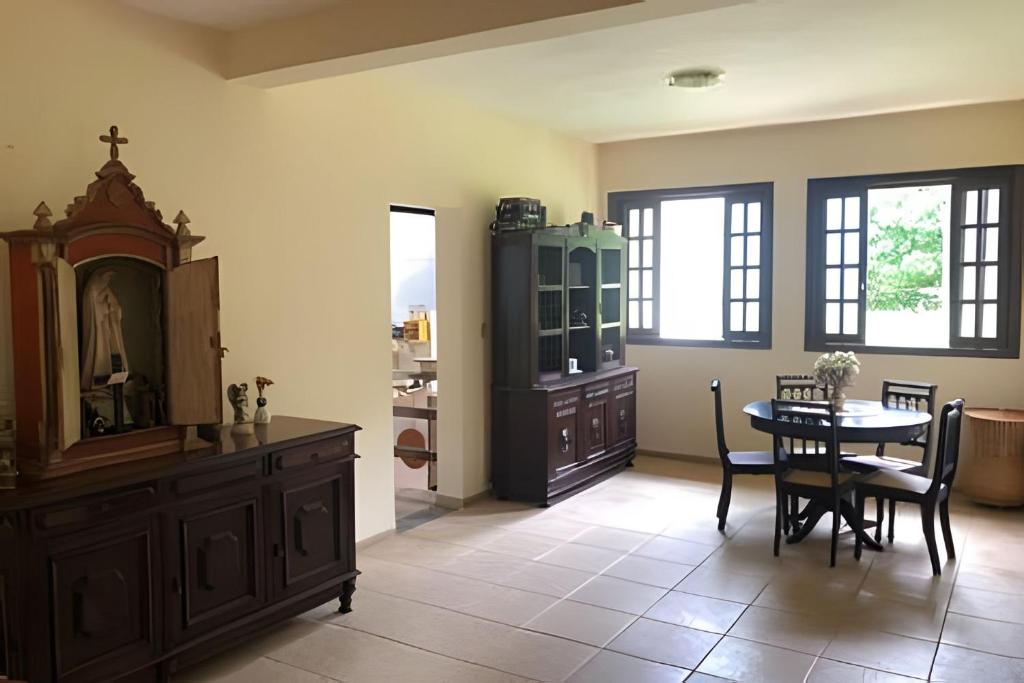 a dining room with a table and a cabinet at Sitio com Piscina AQUECIDa e 5 quartos c/ suíte! in Jaboticatubas