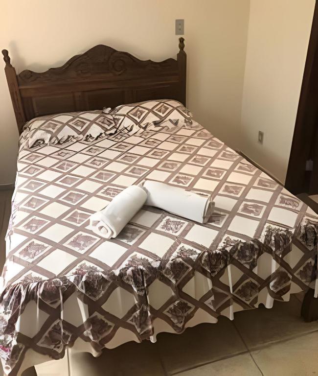 a bed with a black and white comforter at Sitio com Piscina AQUECIDa e 5 quartos c/ suíte! in Jaboticatubas