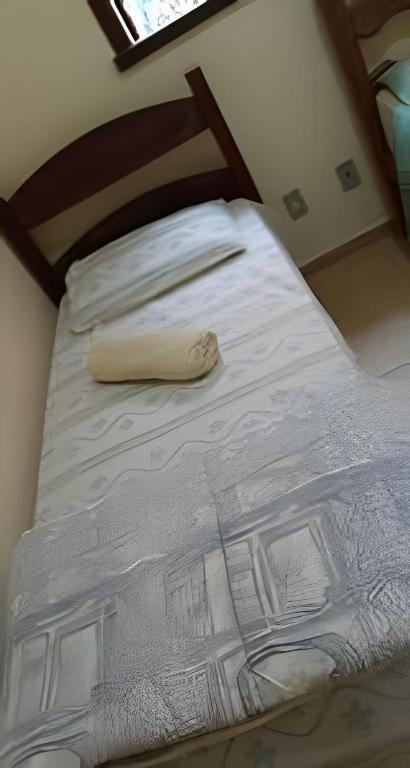 a bed with a wooden headboard and white sheets at Sitio com Piscina AQUECIDa e 5 quartos c/ suíte! in Jaboticatubas