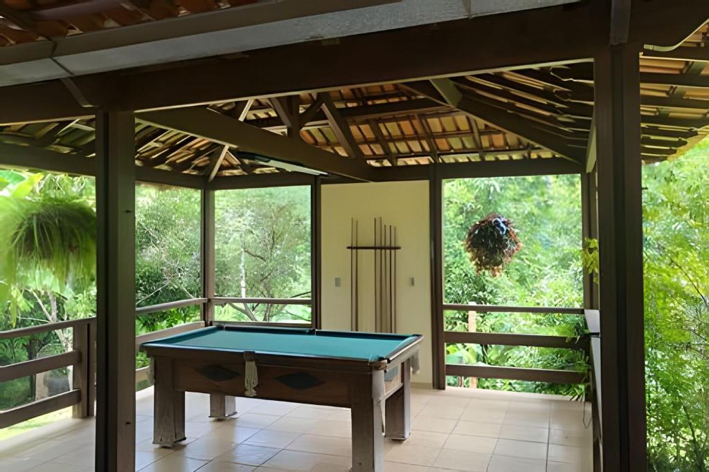 a pool table on a screened in porch at Sitio com Piscina AQUECIDa e 5 quartos c/ suíte! in Jaboticatubas