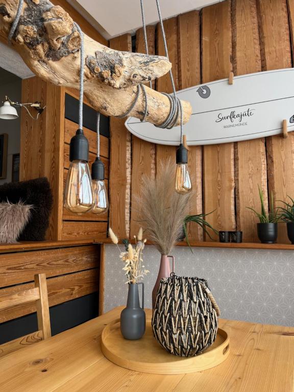 ロストックにあるSURFKAJÜTE - Ferienwohnung in Warnemündeの照明のあるテーブルの上に花瓶が2つ置かれたテーブル