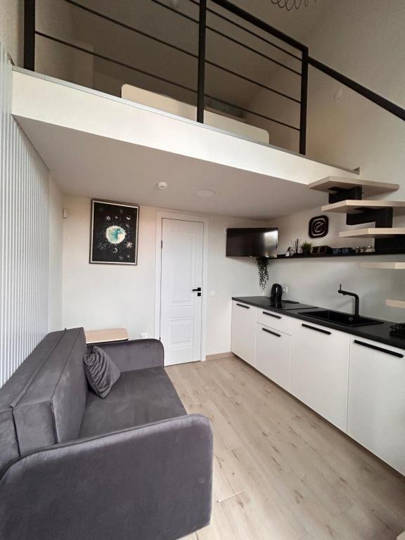 un salon avec un canapé et une cuisine dans l'établissement Urban Nest Palanga, à Palanga