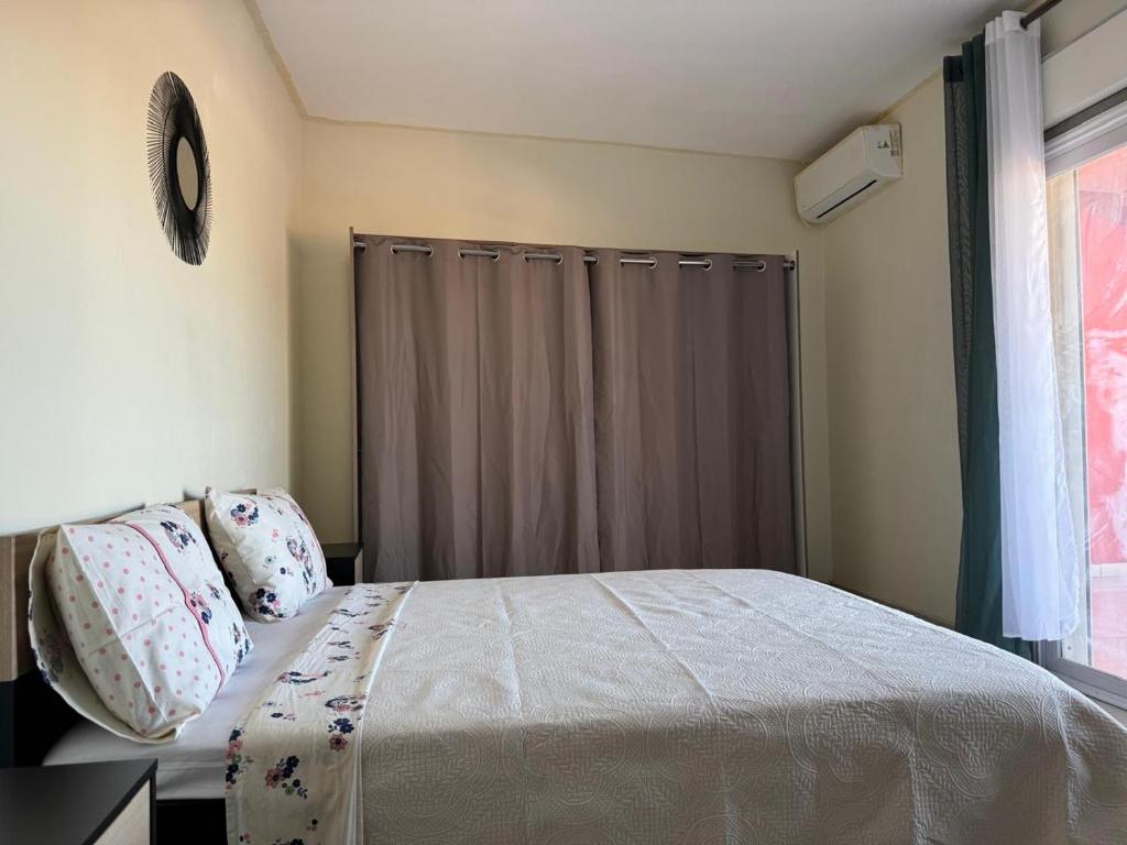 a bedroom with a bed and a window at Résidence la rosée in Mamoudzou