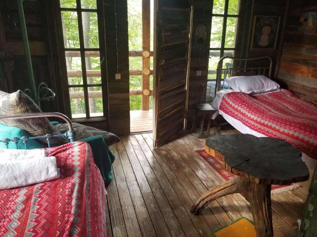 Cette chambre dispose de deux lits et de parquet. dans l'établissement Poet's Hut in The Mountains, à Buriaki