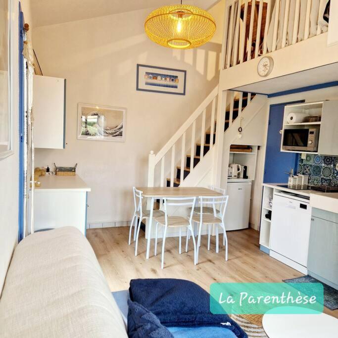 un salon avec une table et une cuisine dans l'établissement La Parenthèse, à Pornic