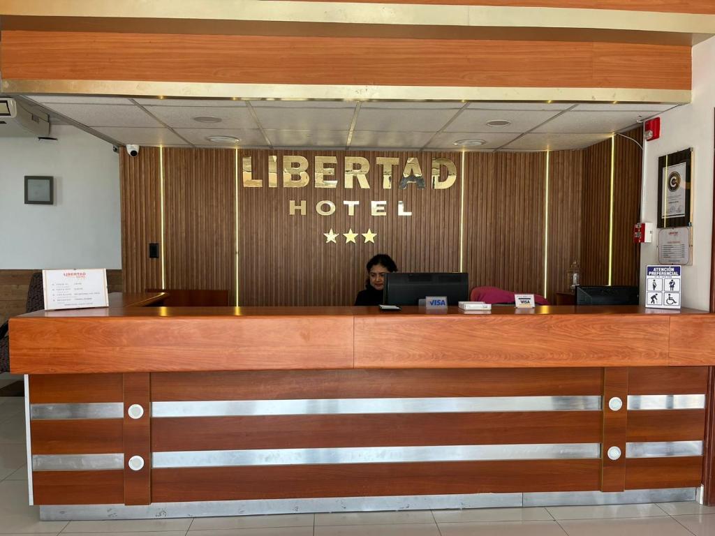 a woman sitting at a desk in a hotel lobby at Hotel Libertad Pacasmayo in Pacasmayo