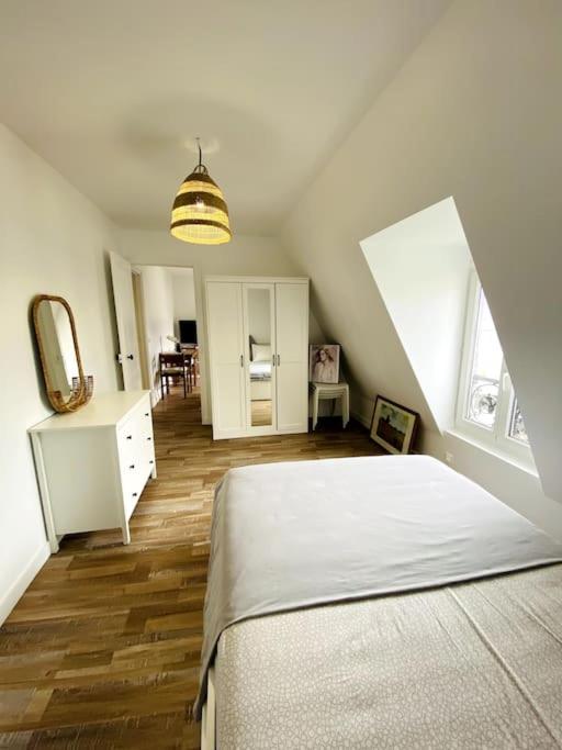 une chambre blanche avec un lit et un miroir dans l'établissement Maj Appart Iéna - Paris 16, à Paris