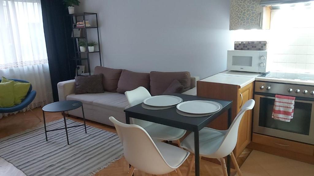 a living room with a couch and a table and chairs at Apartament, 2 pokoje, stacja metra Kabaty, Ursynów in Warsaw