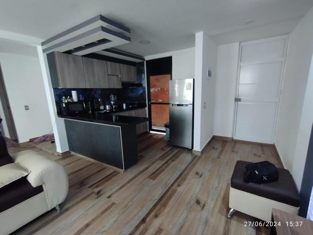 a living room with a kitchen with wooden floors at Apartamento en Cartago Valle - Hospedaje in Cartago