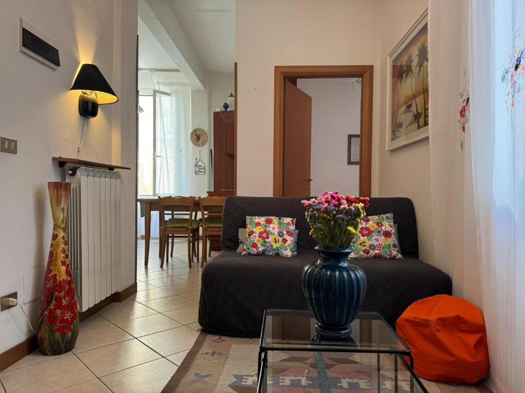 a living room with a couch and a vase with flowers in it at Casa di Peppa in Sanremo