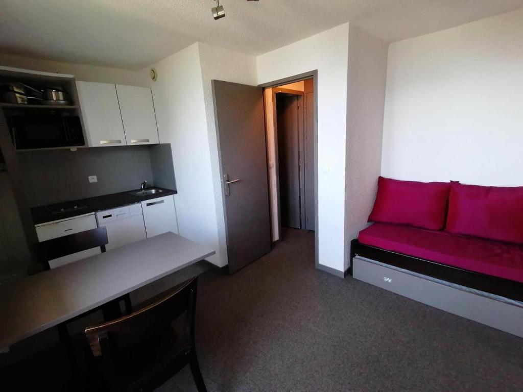 - un salon avec un canapé rouge dans l'établissement Résidence Les Choucas - Studio rénové, pied des pistes MAE-9004, à Aime La Plagne