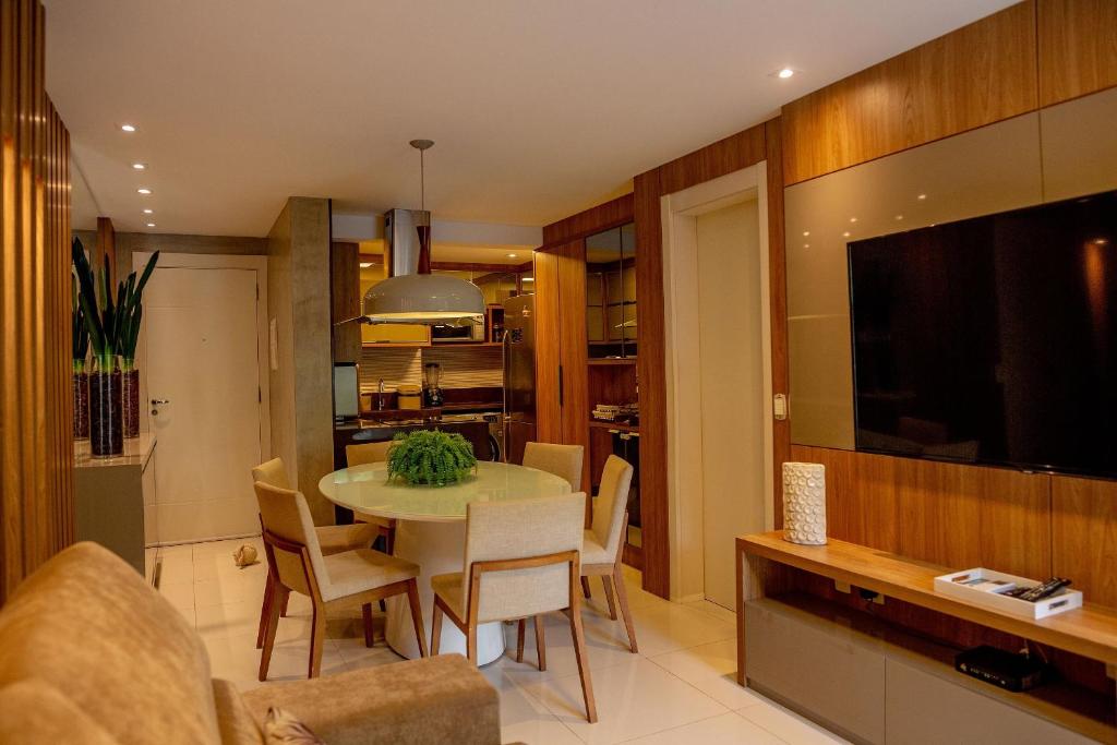 a living room with a table with chairs and a television at In Mare Bali Resort Beira Mar em Cotovelo by Qavi in Granja Beira Mar