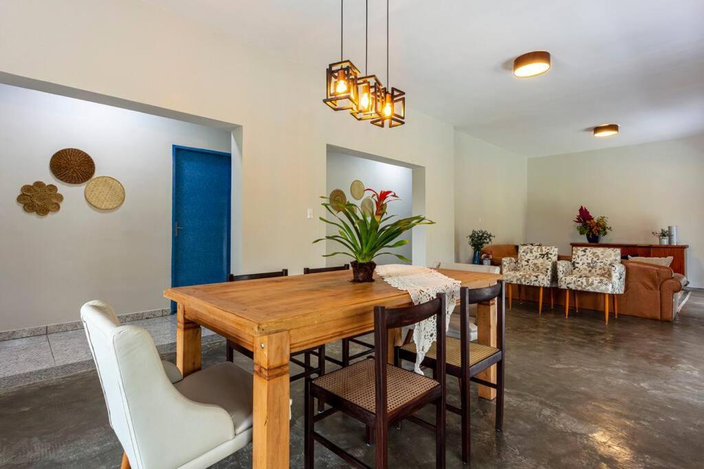 a dining room with a wooden table and chairs at Casa Acuri in Jacareí