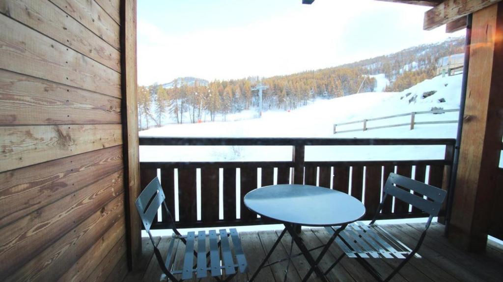 d'une table et de deux chaises sur un balcon enneigé. dans l'établissement Résidence Dame Blanche - DBAC14 - APPT 2 CHAMBRES - BALCON - 6 PERSONNES - Secteur 1800 MAE-4221, à Narreyroux