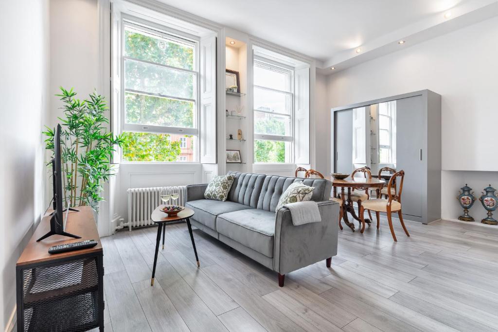 a living room with a couch and a table at Kensington 1bd apt seconds from Museums in London