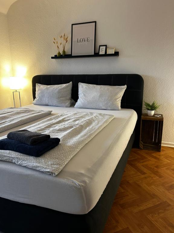 een groot bed met een zwart hoofdeinde in een slaapkamer bij The Climb in Koblenz