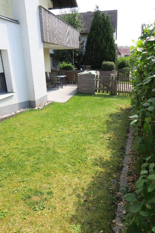 a yard of a house with green grass and a fence at Ferienwohnung Kurzendorfer in Lauterhofen