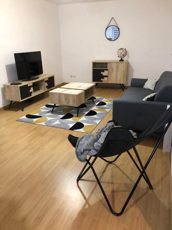 un salon avec un canapé et une chaise dans l'établissement Gîtes des travailleurs et estivants, à Grand-Fort-Philippe