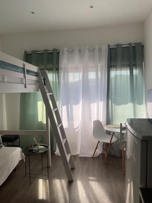 - une chambre avec un lit superposé avec une échelle et une table dans l'établissement La Pépite, à Montbéliard