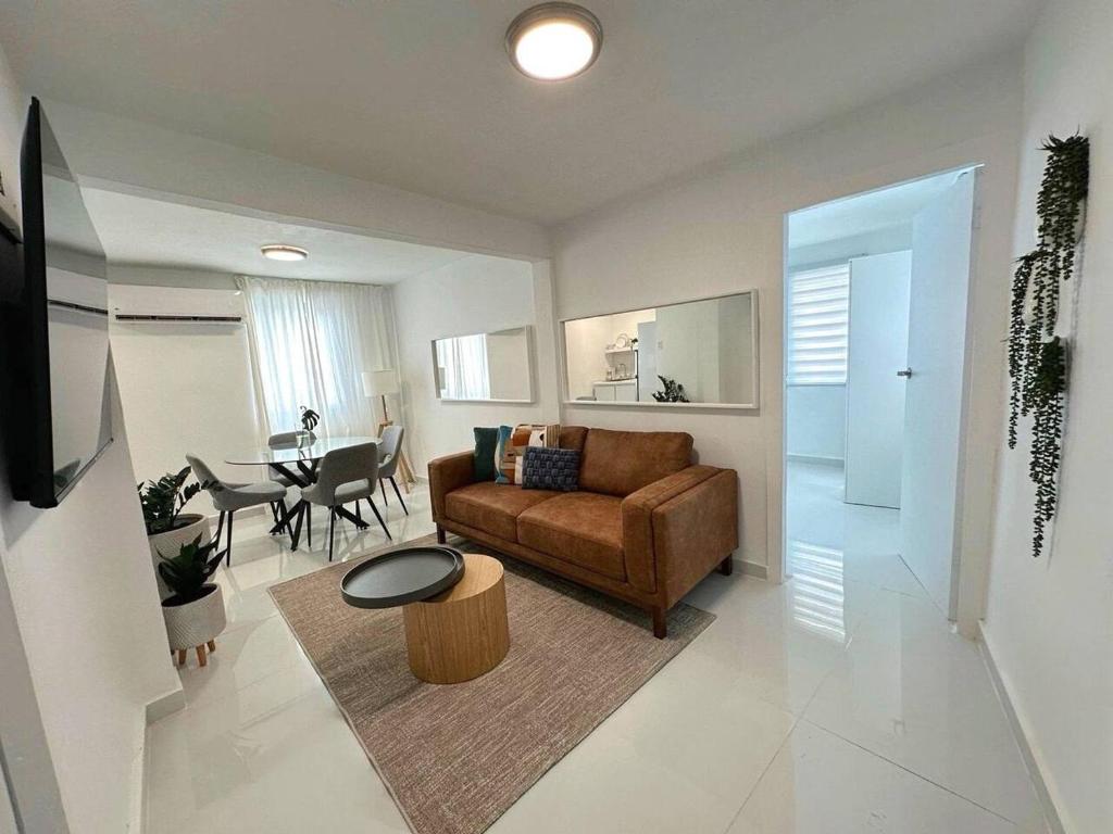 a living room with a brown couch and a table at Chic Apt in Vibrant Santurce V in San Juan
