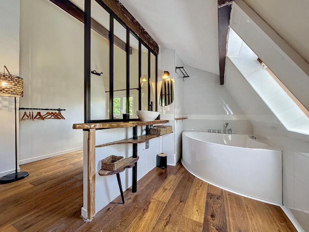a bathroom with a large white tub and a sink at Maison avec jacuzzi et terrasse in Pontault-Combault