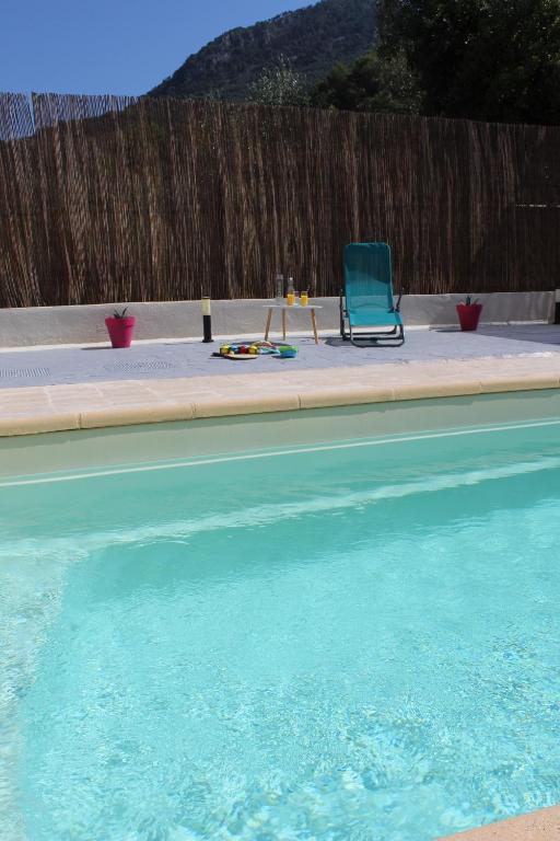 une chaise bleue assise à côté d'une piscine dans l'établissement Charmante Villa individuelle Niçoise avec piscine privée proche Monaco, à Peille