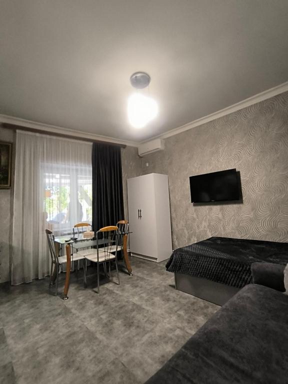 una stanza d'albergo con un letto, un tavolo e una televisione di GRIG's home a Yerevan