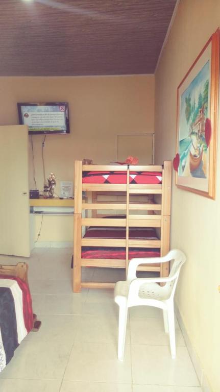 a bedroom with a wooden bunk bed and a white chair at ann dor place 1 in San Andrés