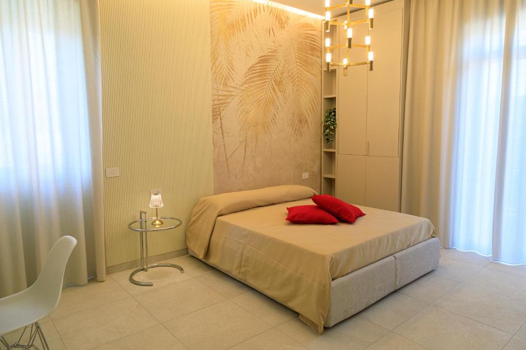 a bedroom with a bed with red pillows on it at Domus Vivian in Montecorvino Pugliano