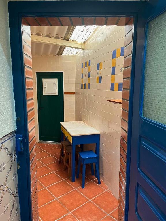 a small room with a table and a blue door at Casa do Viajante in Cabeção