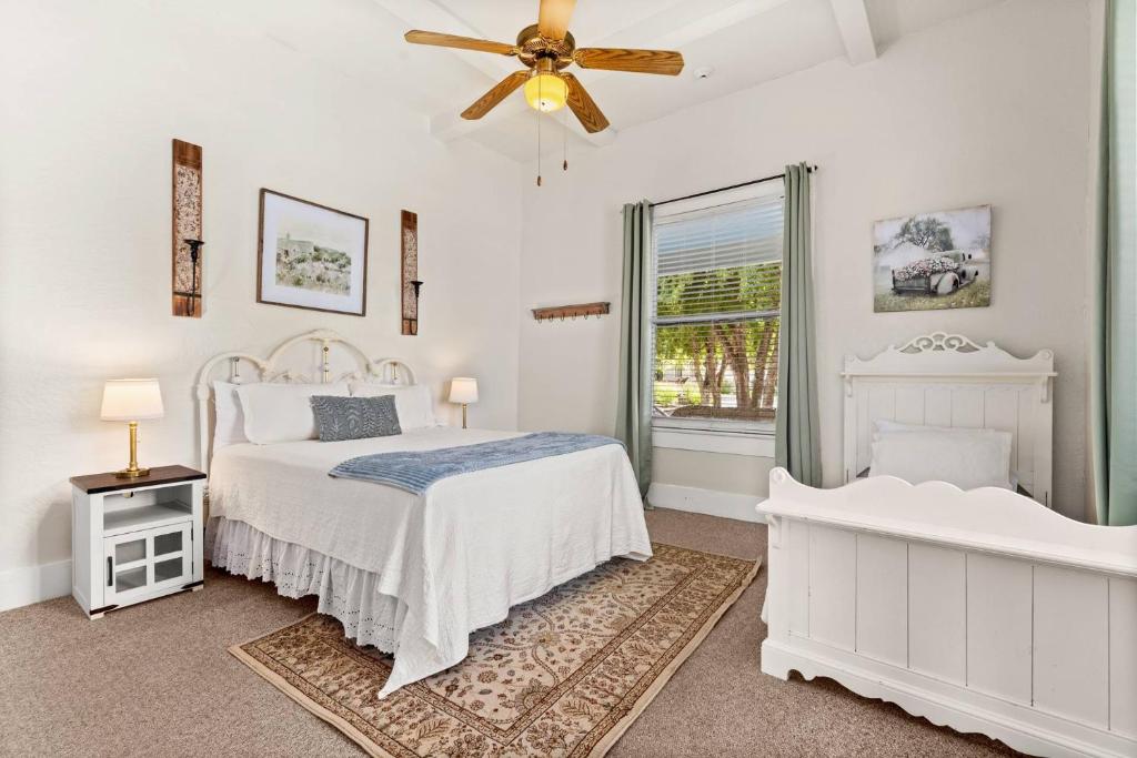 a white bedroom with a bed and a ceiling fan at #14 The Country Suite at Garrison in Gruene in New Braunfels