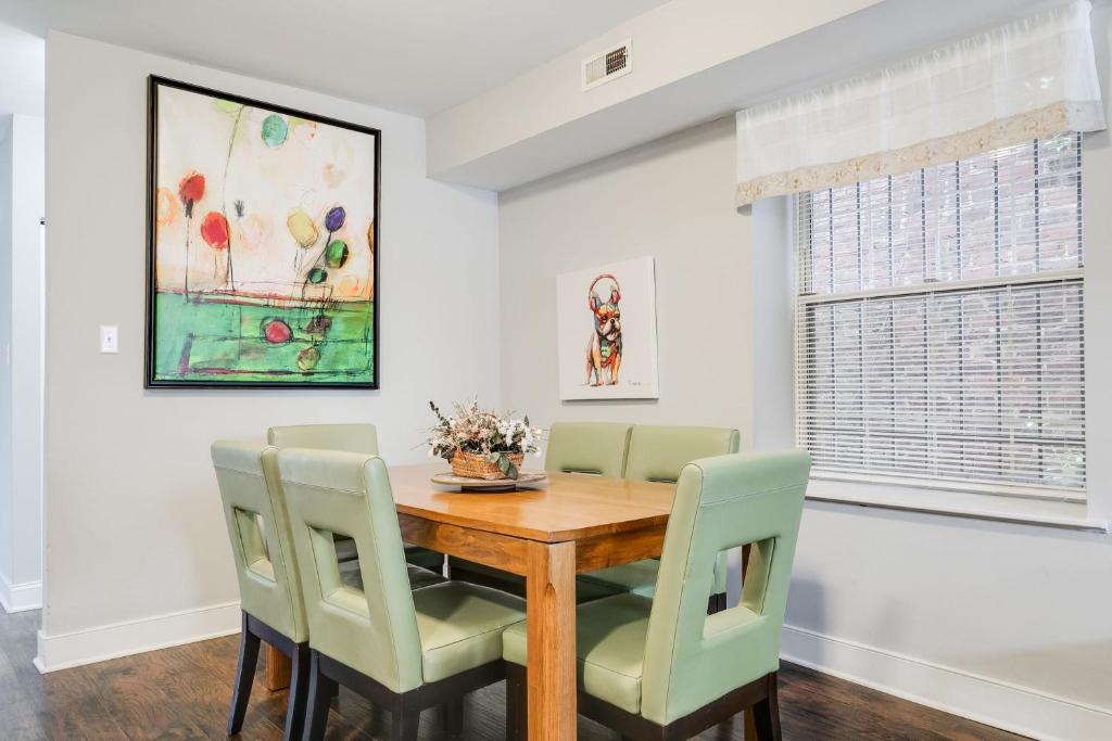 una sala da pranzo con tavolo in legno e sedie verdi di Cozy spacious family home near Carytown fully fenced a Richmond