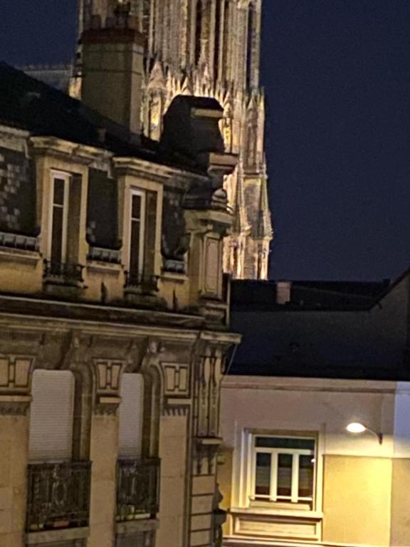 un bâtiment avec une tour d'horloge en arrière-plan dans l'établissement IXO’s The Suite, à Reims