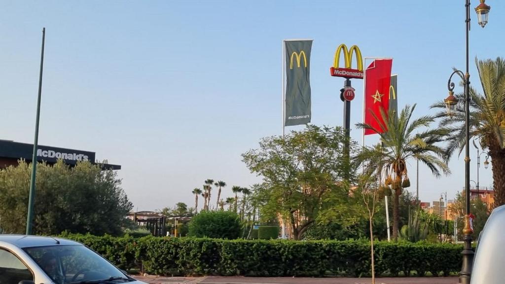a car parked next to a mcdonalds sign and flags at Appartement Mima Marrakech Proche centre ville, cosy et spacieux in Marrakech