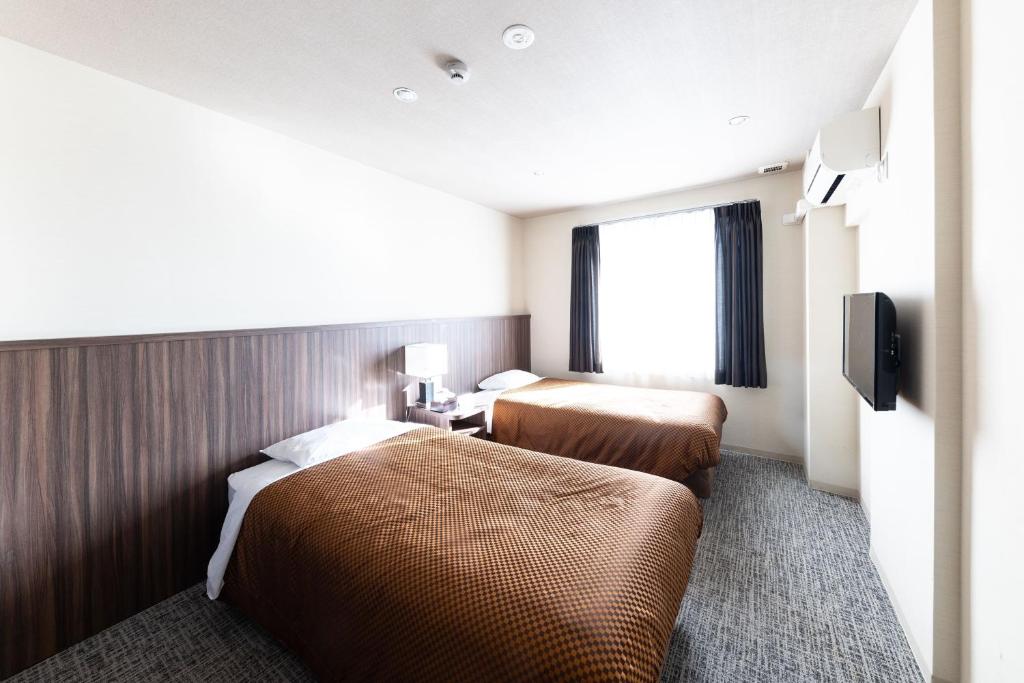 Postel nebo postele na pokoji v ubytování Reco Hotel Mikuni