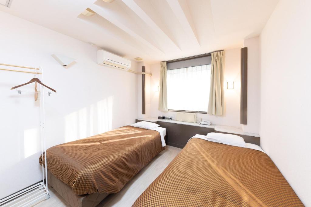 Postel nebo postele na pokoji v ubytování Reco Hotel Mikuni