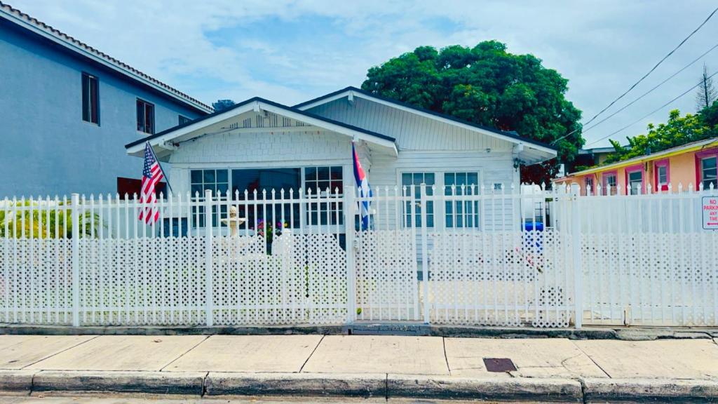 a white fence in front of a white house at Dreams by MyMiamiStay in Miami