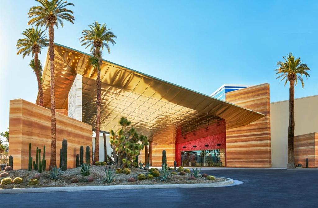 a building with palm trees in front of it at Virgin Hotels Las Vegas by Suiteness in Las Vegas