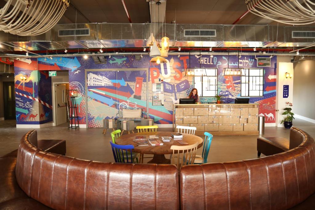 a restaurant with a table and chairs and a wall with graffiti at The Post Hostel Jerusalem in Jerusalem